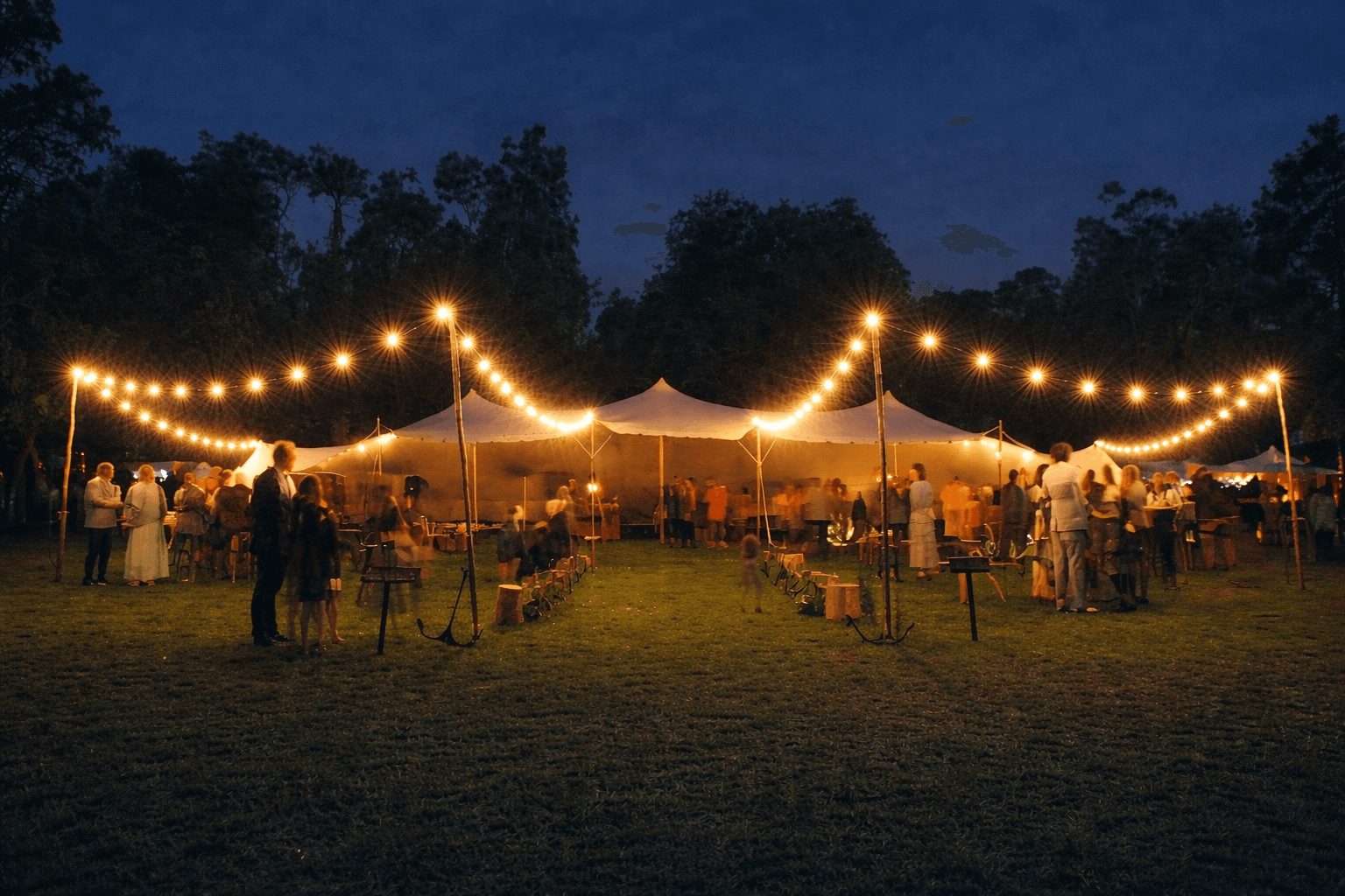 Stretch tent lit with festoon lights at an evening outdoor event